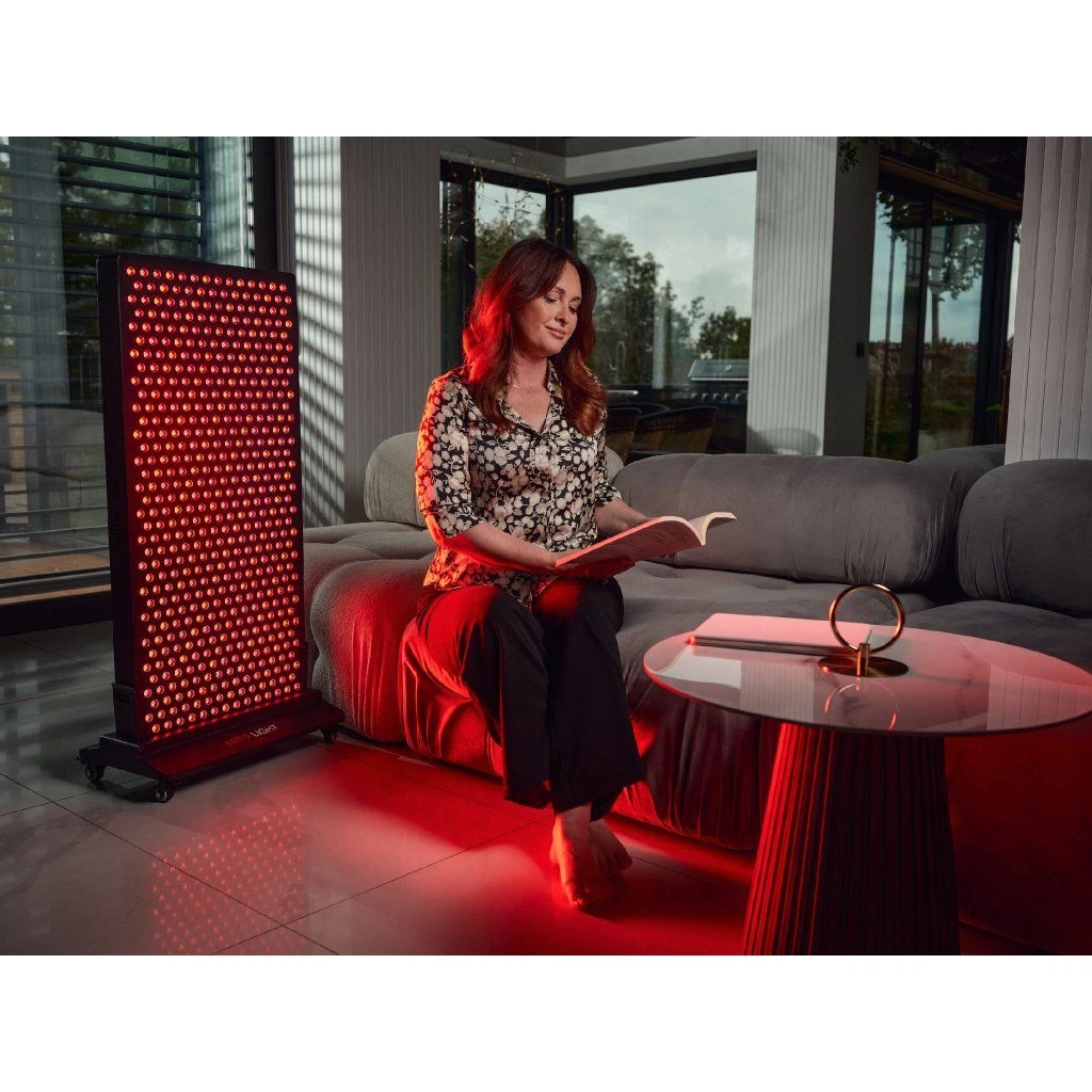 stojan-mito-light-mitohacker-floor-stand-5-0-7 Žena číta knihu pri paneli MITO LIGHT® Mitohacker 5.0 na stojane Mitohacker Floor Stand 5.0 – terapia červeným svetlom počas relaxu